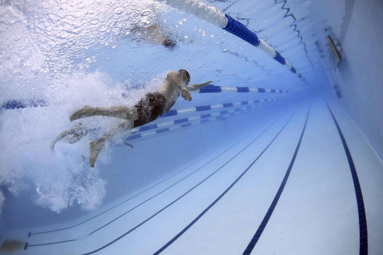 Dynamic image of swimmers in an underwater pool race showcasing freestyle techniques.